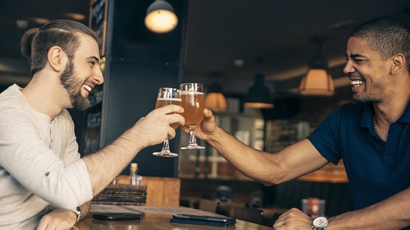 Zwei Männer stoßen mit Bier an