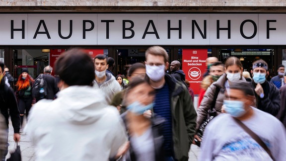Reisende mit Mund-Nasen-Schutz vor dem Hauptbahnhof von Düsseldorf