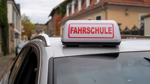 Ein Fahrschulauto mit einem Schild auf dem "Fahrschule" steht