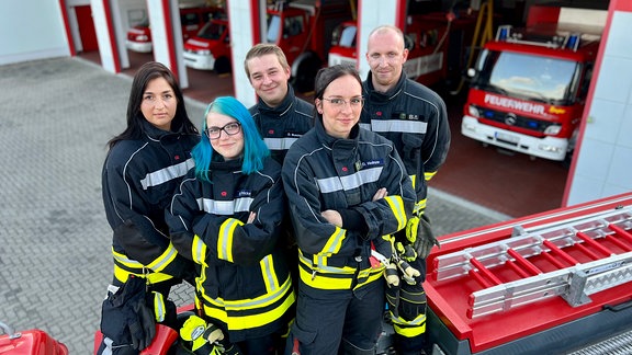 Fünf Feuerwehrleute der Freiwilligen Feuerwehr in Ascherslebene stehen auf einem Feuerwehrwagen