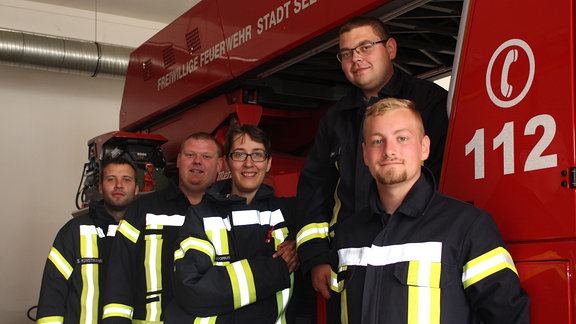 Fünf Feuerwehrleute der Freiwilligen Feuerwehr in Seeland stehen vor einem Feuerwehrwagen.