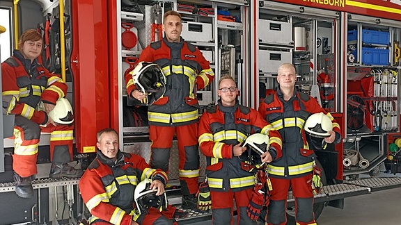 Fünf Feuerwehrleute der Freiwilligen Feuerwehr in Sonneborn stehen vor einem Feuerwehrwagen
