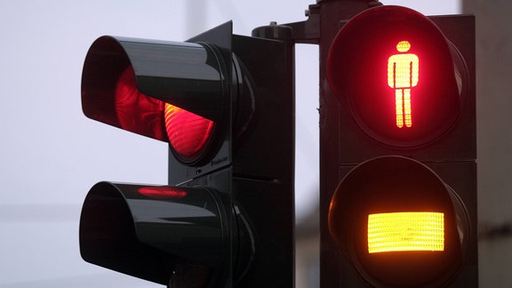 Rote Ampel für den Straßenverkehr, Fußgänger erwarten das Umspringen von rot-gelb auf grün