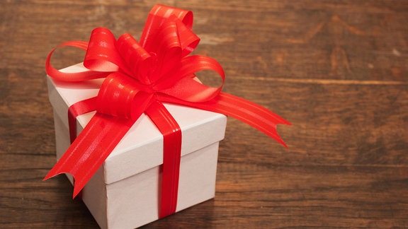 Geschenkbox, weiß mit roter Schleife. Ein Weihnachtsgeschenk?