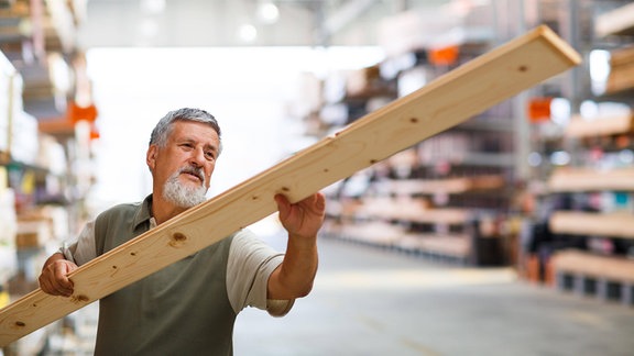 Ein Mann überprüft ein Holzbrett im Holzhandel