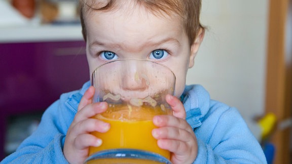 Kleines Kind trinkt Orangensaft