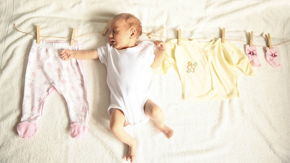 Schlafendes Baby und Kinderkleidung